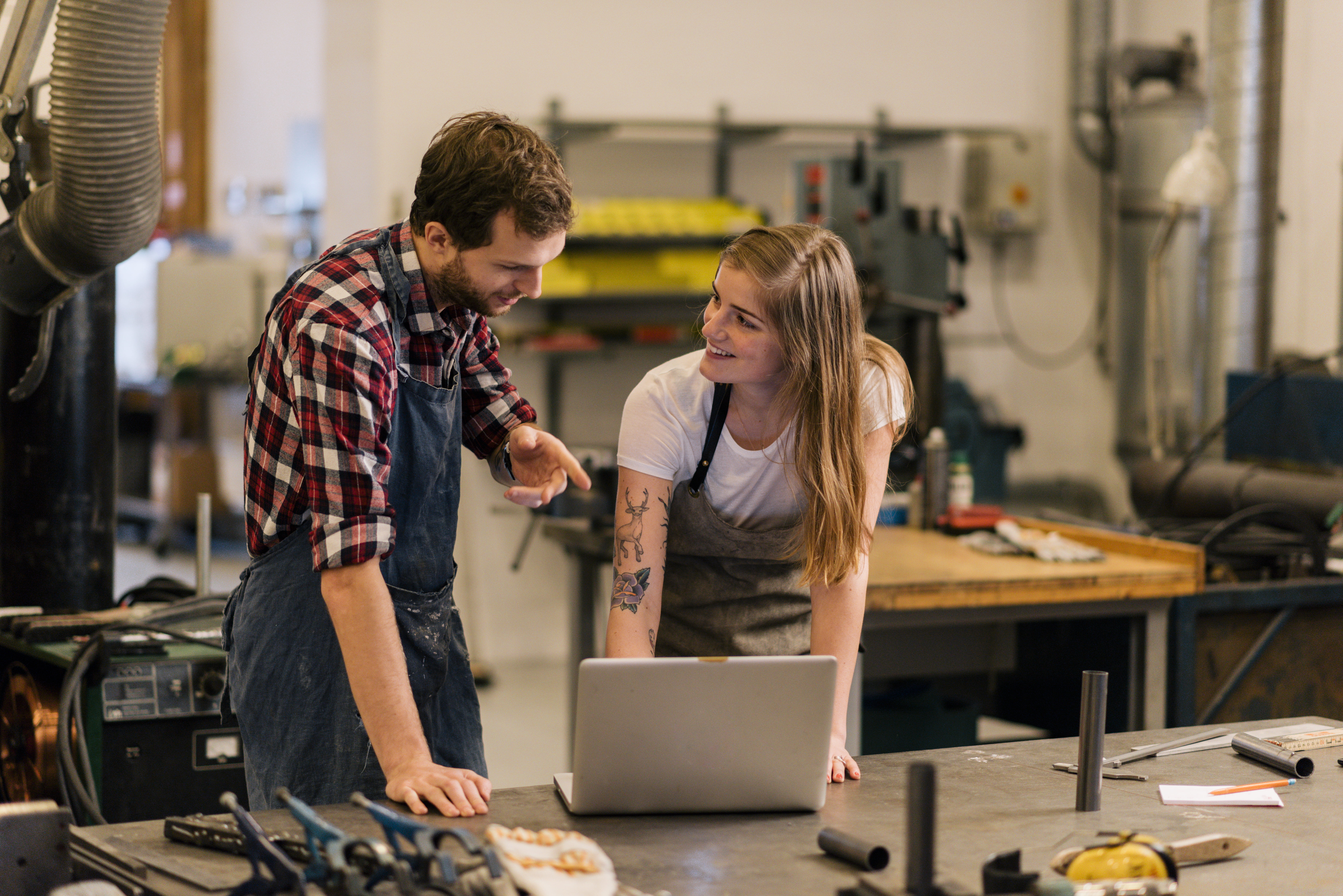 Mann og kvinne som snakker sammen i et snekkerverksted